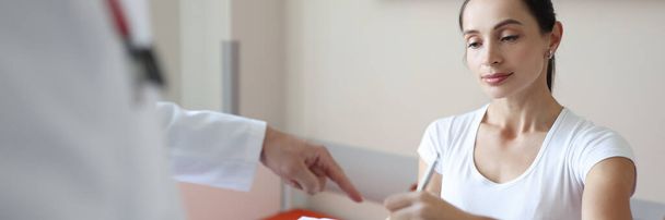 Patientin unterschreibt ärztliche Dokumente beim Arzttermin - Foto, Bild