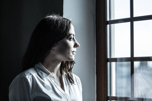  Portrait of a woman in a office near window, toned drama effect and some grain  - Photo, Image
