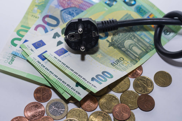 Energy prices increase and energy consumption power cable with knot and euro bills and coins detail view - Photo, Image