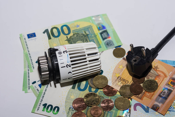 Zvýšení cen energií a pohled shora na termostatický regulátor vytápění a elektrické zástrčky - Fotografie, Obrázek