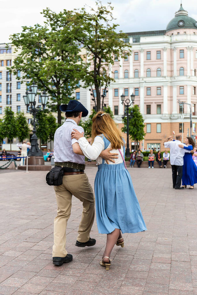Romantic couple dancing in the square. A man and a woman enjoy life. Dancing in the street. - Фото, зображення