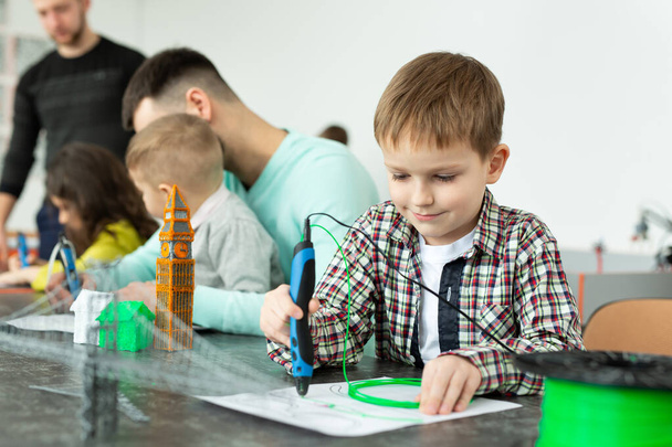 Child using 3D printing pen. Boy making new item. Creative, technology, leisure, education concept. - Zdjęcie, obraz