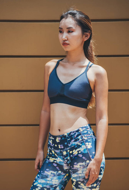 Portrait of Sporty Woman Preparing for a City Running. Confident female athlete looking away while taking a break of outdoor workout training. - Photo, Image