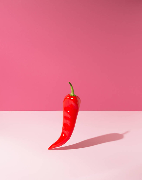 A front view of a red pepper on a pink background. Minimal concept. - Foto, immagini