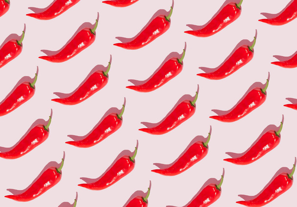 Pattern out of red peppers on a pink background. Minimal concept. - Foto, afbeelding