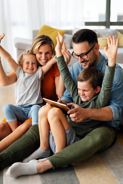 Digital device technology family online education concept. Happy young family with digital devices at home. - Фото, изображение
