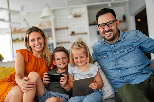 Digital device technology family online education concept. Happy young family with digital devices at home. - Фото, зображення
