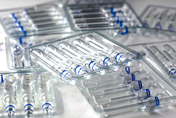 récipients transparents en plastique avec ampoules en verre sur fond blanc. Photo de haute qualité - Photo, image
