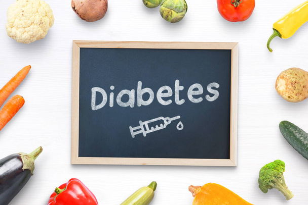 Diabetes concept composition with chalkboard in the middle with text and insulin injection drawing surrounded by healthy food, vegetables - Photo, image