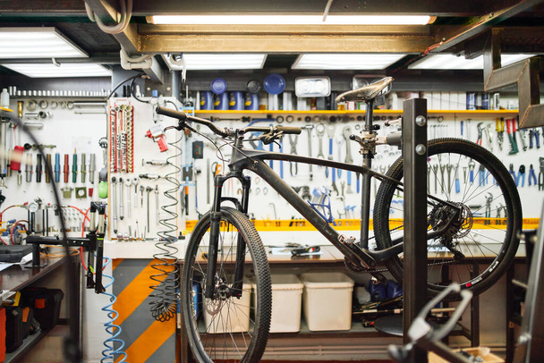 Bicycle on rack in workshop - Фото, зображення