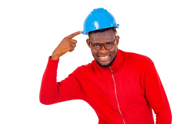 fiatal férfi építőmérnök visel kék kemény kalap és ujjal mutogató mosolygós. - Fotó, kép