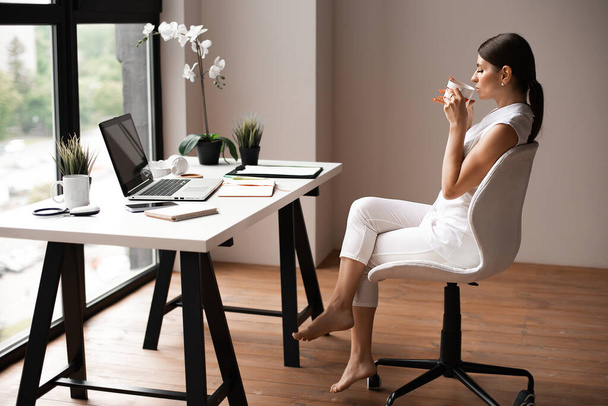 working young business woman from home sitting on floor with laptop. - 写真・画像