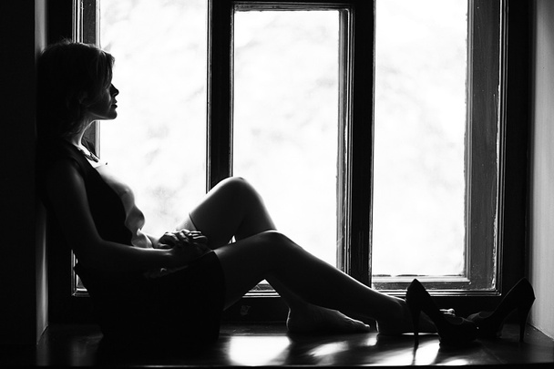 Woman sitting on the windowsill - 写真・画像