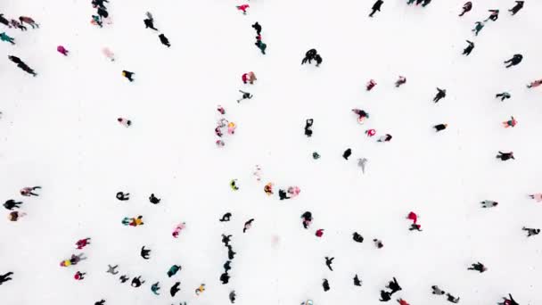 Drohnenblick über viele Menschen, die im Winter auf einer Eisbahn unter freiem Himmel Schlittschuh laufen. - Filmmaterial, Video