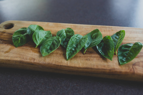 freshly picked basil leaves on wooden cutting board, concept of simple natural healthy ingredients - Zdjęcie, obraz