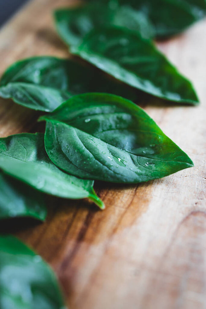 freshly picked basil leaves on wooden cutting board, concept of simple natural healthy ingredients - Zdjęcie, obraz