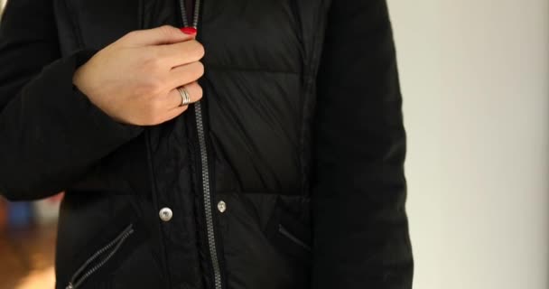 Γυναικείο χέρι λύστε το φερμουάρ σε ένα μαύρο σακάκι - Πλάνα, βίντεο