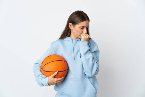 Giovane donna lituana che gioca a basket isolato su sfondo bianco avendo dubbi - Foto, immagini