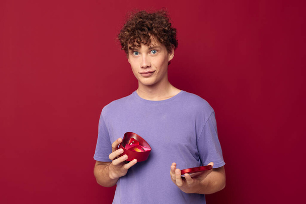 young man heart shaped gift red background - Fotó, kép