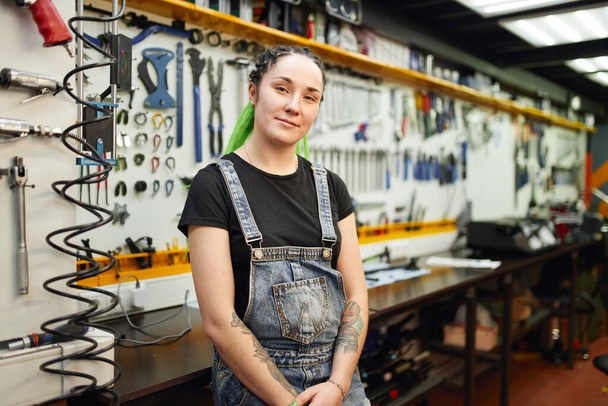 Female mechanic with tattoos in workshop - Фото, зображення