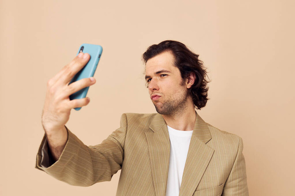 man in a suit posing emotions looking at the phone isolated background - Foto, afbeelding