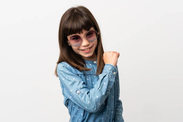 Güneş gözlüklü küçük kız beyaz arka planda soyutlanmış gururlu ve kendinden memnun - Fotoğraf, Görsel