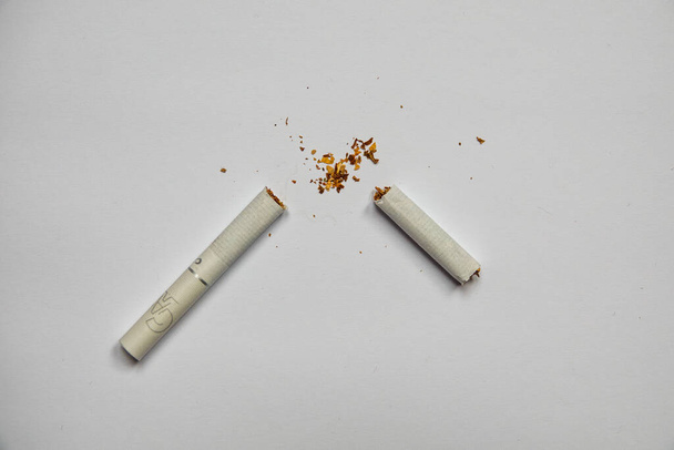 Broken cigarette on a white background. - Foto, imagen