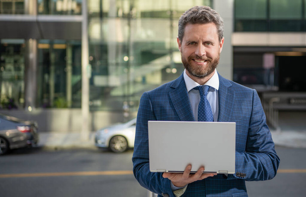 happy mature business man in formalwear work on modern laptop outdoor, copy space, presentation - Фото, изображение
