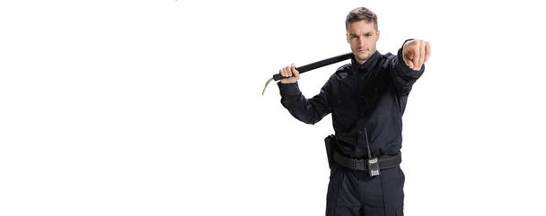 Flyer with young male policeman officer wearing black uniform posing isolated on white background. Concept of job, caree, law and order. - Foto, Imagem