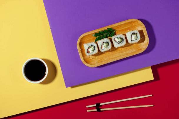 Sushi on a plate on a bright, colored background. - Foto, afbeelding