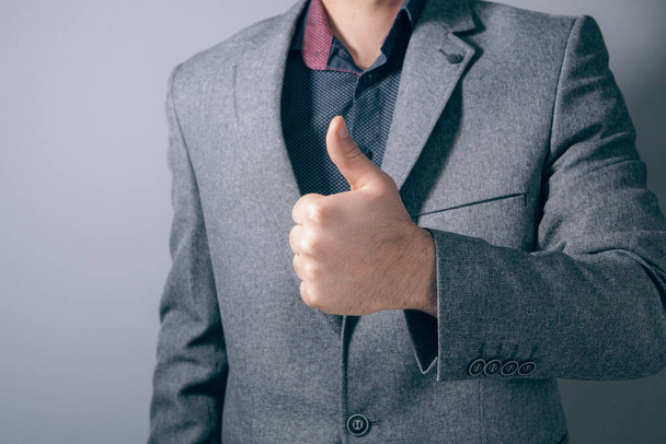 young businessman showing thumbs up - Foto, afbeelding