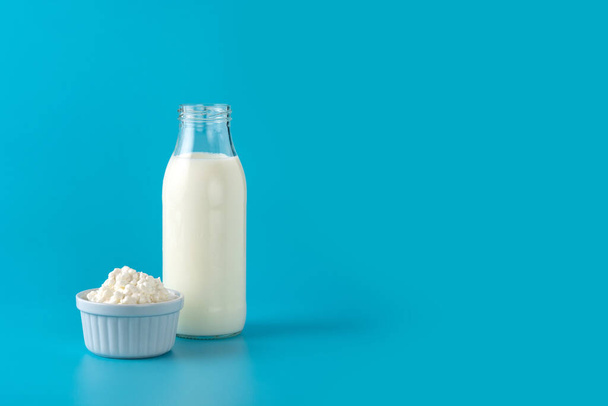 Mleko kefir napój na drewnianym stole. Płynny i sfermentowany produkt mleczny na niebieskim tle - Zdjęcie, obraz