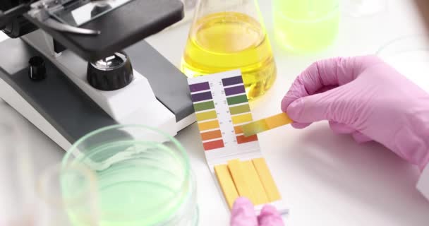 Chemist in lab checking with ph strips closeup - Footage, Video