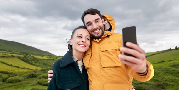 couple taking selfie with smartphone in ireland - 写真・画像