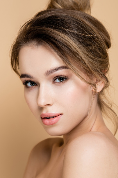 close up portrait of young woman with natural makeup looking at camera isolated on beige - Foto, Bild