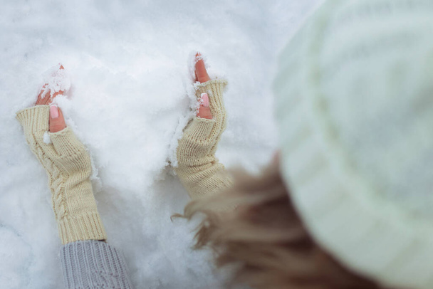 Detailní záběr Sněhové srdce v rukou v pletených rukavicích na pozadí sněhové pokrývky. Valentýn - Fotografie, Obrázek