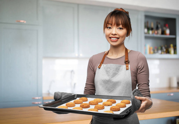 happy woman with cookies on oven tray at kitchen - Fotografie, Obrázek