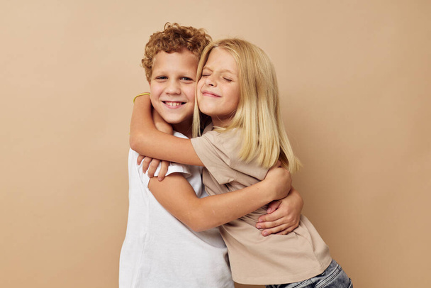 boy and girl in t-shirts hugs beige background friendship - Фото, зображення