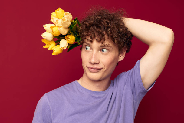 A young man red hair in casual wear bouquet of flowers gift isolated background unaltered - Fotó, kép