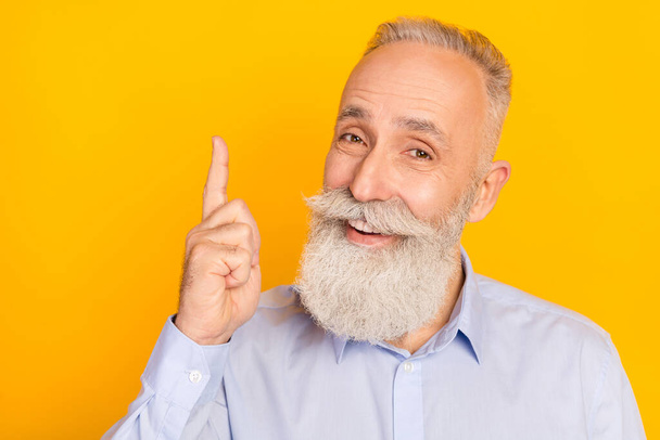 Photo of happy retired grey haired positive old man point finger up empty space smile isoalted on yellow color background - Foto, Imagem