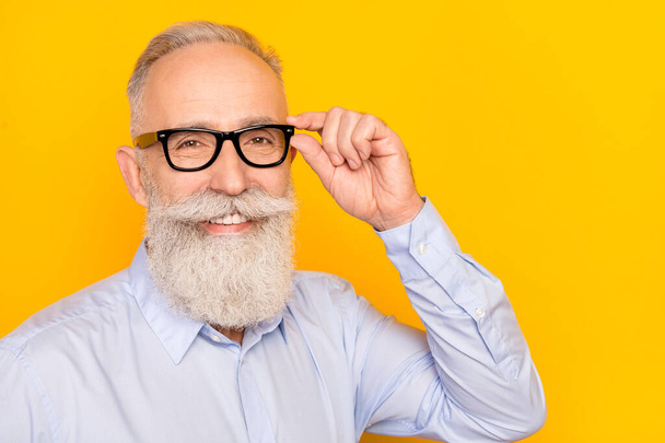 Photo of cute sweet age gentleman wear blue shirt arm dark glasses empty space isolated yellow color background - Foto, afbeelding