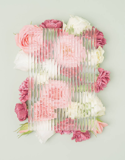Coloridas flores de jardín sobre un fondo pastel con placa de vidrio corrugado en la parte superior. Vida virtual concepto mínimo. - Foto, Imagen