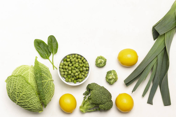 Savoy cabbage, three lemons, leek, broccoli and green peas in bowl.  Copy space. Flat lay. White background - Foto, immagini