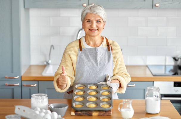 woman with cupcakes in baking mold on kitchen - Fotoğraf, Görsel