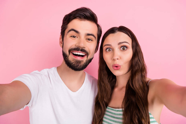 Photo of positive blogger couple take selfie posing wear casual outfit isolated pink color background - Foto, Imagen