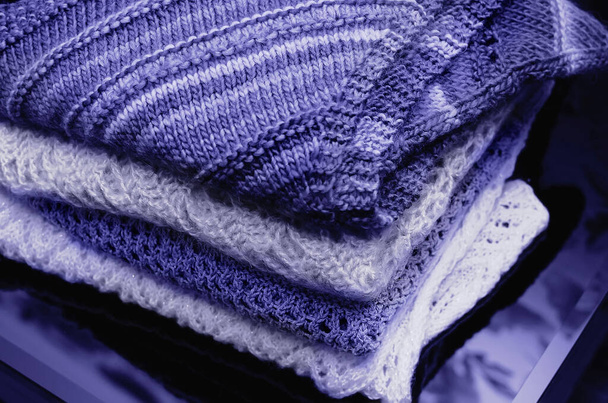 Stack of warm knitted clothes of trendy very peri color, violet blue, lavender - Foto, afbeelding