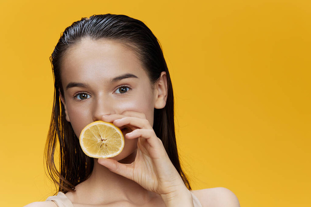 женщина с лимоном рядом с лицом чистый уход за кожей здоровье крупным планом образ жизни - Фото, изображение