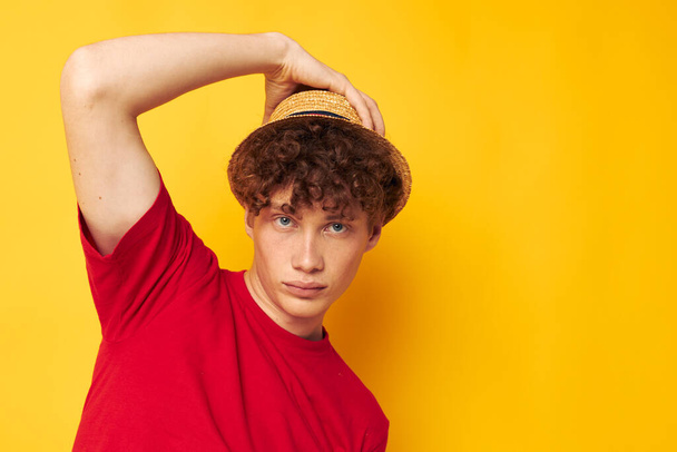 Young curly-haired man in a red t-shirt with a fashion hat Lifestyle unaltered - Foto, Imagem