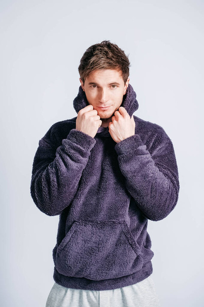 Portrait of a young man in purple sweatshirt with hood on a white background. Copy, empty space for text - Fotoğraf, Görsel
