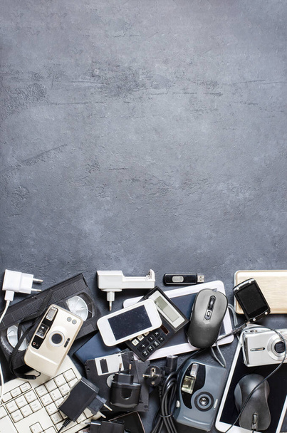 Old electronic devices on a dark background. The concept of recycling and disposal of electronic waste. Copy space. - Foto, imagen